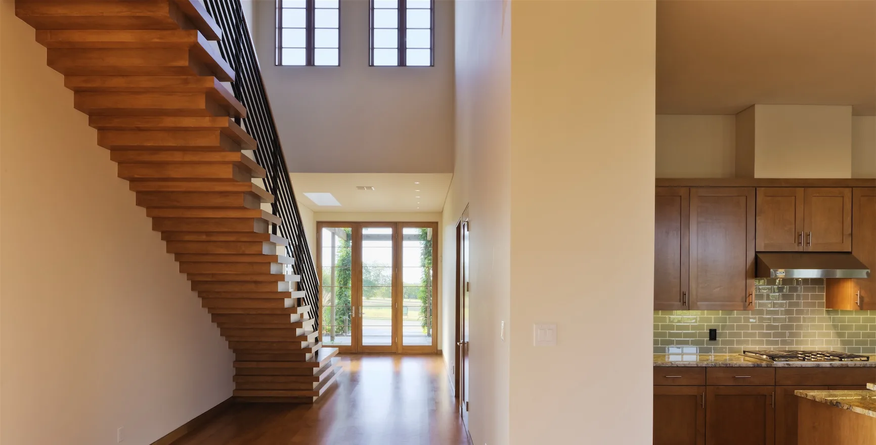 Open interior with wood stairs and a new kitchen near completion